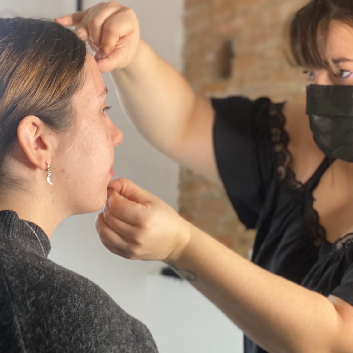 Soin épilation au fil professionnel chez makeup design à Toulouse, esthéticienne concentrée sur le visage d’une cliente